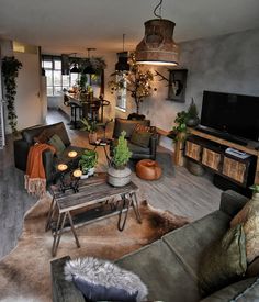 a living room filled with furniture and lots of plants on top of the tables in front of them