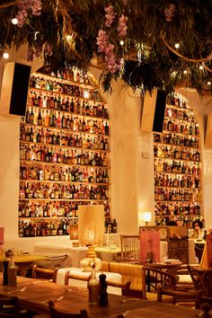 a restaurant with lots of bottles on the wall and lights hanging from the ceiling above it