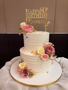 a white cake with pink and yellow flowers on top