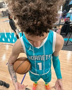 a young man holding a basketball on top of a court