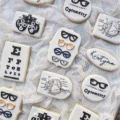 decorated cookies with different types of glasses and eyeglasses on top of white lace