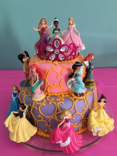 there is a cake decorated with princess figurines on it