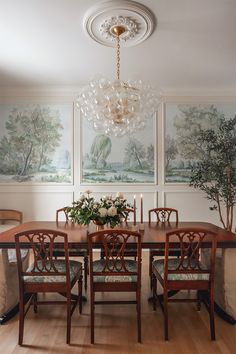 a dining room table with chairs and a chandelier hanging from it's ceiling