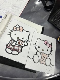 an open book with hello kitty on it next to a computer keyboard and mouse pad