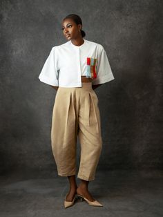 Babayo’s Balloon Pants are named after their exaggerated barrel legs that curve at the sides. They’re cut from hand-woven Aso Oke cotton and tailored to a relaxed, high-waisted profile that hits just right above the ankle. The fitted waistband and pleated detailing enhance the dramatic shape, while the versatile sand shade means they’re incredibly versatile when it comes to styling. - Fitted waist, pleated detailing, side zip fastening, side pockets, cropped length- Cotton - Crafted by female ar Barrel Pants, African Luxury, Dress Stole, Corporate Attire, Balloon Pants, Embroidered Crop Tops, Aso Oke, Wool Embroidery, Red Carpet Ready