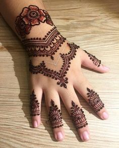 henna tattoo on the palm of a woman's hand with flowers and leaves