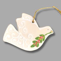 an ornament shaped like a bird with holly berries on it's wings