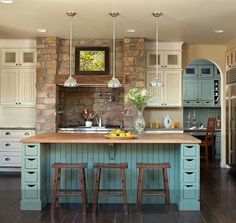 a kitchen with two stools next to an island in the middle of the room