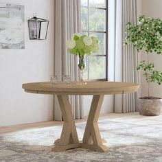 a wooden table sitting in front of a window next to a potted plant