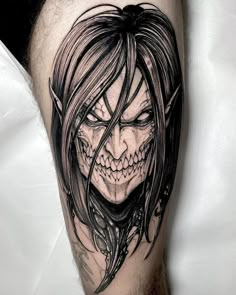 a man's leg with a black and white tattoo design on it, featuring a demon