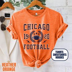 Please Note: This listing contains multiple shirt types. To insure you are getting the item you expect, please review all options and photos carefully before ordering. Our Chicago Football Apparel is the perfect way to cheer on your team this season. Choose from short sleeve tees, sweatshirts or hoodies. Makes a great gift for any fan. Perfect for game day, tailgates or everyday wear.  SHIRT DETAILS Bella Canvas Unisex - Solid colors: 100% Cotton. - Heather colors: 52% Cotton + 48% Polyester - Runs true to size. (For looser or oversized fit consider going up a size or 2. See photos for size chart.) SWEATSHIRT & HOODIE DETAILS Gildan Heavy Blend Unisex - 50% Cotton + 50 Polyester - Runs true to size. (For looser or oversized fit consider going up a size or 2. See photos for size chart.) CAR Orange Letter Print Crew Neck Hoodie, Team Spirit Sports T-shirt For Fall, Fall Varsity Sports T-shirt, Varsity Sports T-shirt For Fall, Varsity Style Sports T-shirt For Fall, Orange Crew Neck T-shirt With Team Name, Winter Sports T-shirt With Letter Print, Fall Sports T-shirt With Letter Print, Collegiate Winter T-shirt With Team Name