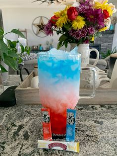 a blue and red drink sitting on top of a counter next to some candy bars