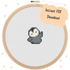 a cross stitch penguin is shown in the hoop