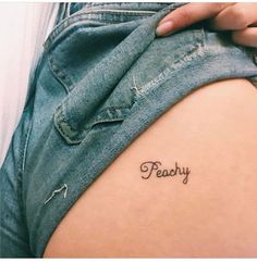 a person with a small tattoo on their arm that says peachy in cursive writing