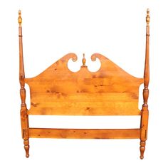 a wooden bed frame with two posts on each side and an arched headboard at the end