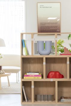 a book shelf with books and other items on top of it in a living room