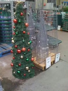 a small christmas tree sitting on top of a wooden pallet in a room filled with crates