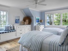 two beds in a bedroom with blue walls and white trim on the windowsills