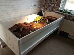 a bed with an open book on top of it in front of a brick wall