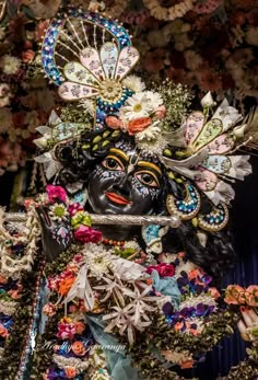 an elaborately decorated statue in front of flowers