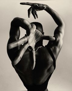 a black and white photo of a man with his hands in the air