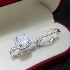 an engagement ring in a box with diamonds on the inside and outside, sitting next to each other