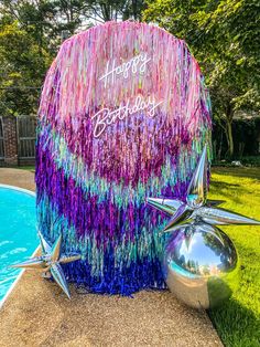 a birthday decoration next to a swimming pool