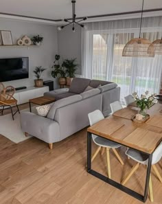 a living room filled with furniture and a flat screen tv on top of a wooden table