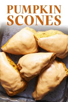 pumpkin scones with orange icing in a pan