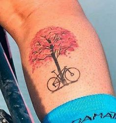 a person with a bike and tree tattoo on their arm