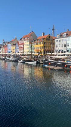 several boats are docked in the water next to some buildings