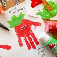 children's handprints and craft supplies on a table with markers, pens, glue and paper