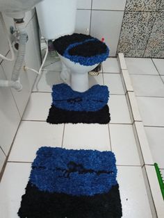 two blue rugs on the floor in a bathroom