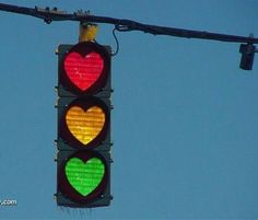 a traffic light with two hearts painted on it's red, green and yellow lights