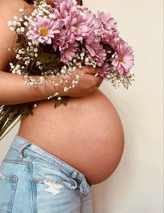 a pregnant woman holding flowers in her belly