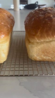 two loaves of bread sitting on a cooling rack