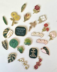 a collection of pins and magnets on a white surface, including broccoli