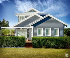 a blue and white house sitting on top of a lush green field