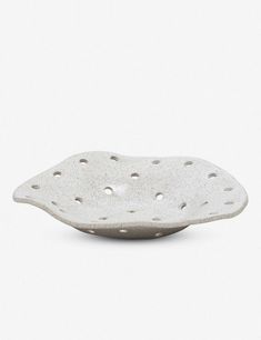 a white ceramic bowl with holes in it