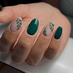 This design is a beautiful blend of solid green nails with delicate botanical accents. The combination of dark green polish and subtle leaf designs on a nude base creates a sophisticated and nature-inspired look, ideal for the fall season. The rounded shape of the nails adds a soft, feminine touch.   Photo credit by: @anii_nails Nail Designs Vines, Green And Neutral Nails, Terracotta Nails Designs Wedding, Simple Dark Green Nail Designs, September Nails Green, Nail Art On Green Nails, Pine Green Nails Design, Nokti 2022, Wreath Nail Design