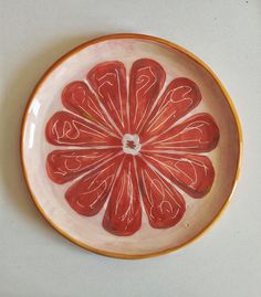 an orange slice is in the center of a bowl on top of a white table