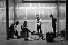 three men are playing instruments in an empty room