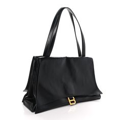 This is an authentic BALENCIAGA Paper Calfskin Medium Crush Top Handle Shoulder Bag in Black. This handbag is crafted of textured calfskin leather in black. The bag features dual top handles and prominent gold B logos on the front and back flaps. These open to smooth black leather interiors. The top magnet opens to a black leather interior with a zipper pocket. Shoulder Bag Black, Leather Interior, Top Handle, Zipper Pocket, Calf Skin, Balenciaga, Black Leather, Handles, Shoulder Bag