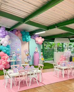 a room filled with tables and chairs covered in balloons