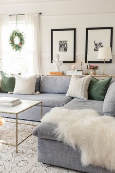 a living room filled with furniture and pillows on top of a white carpeted floor