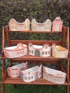 three tiered wooden shelf with ceramic houses on it