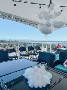 an outdoor dining area with blue chairs and white chandelier hanging from the ceiling