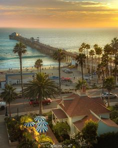 an aerial view of the beach and pier at sunset