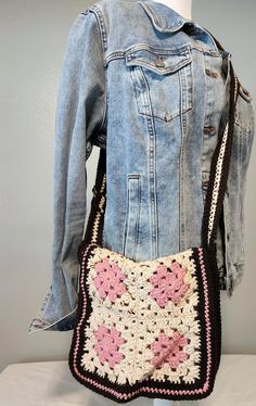 a crocheted purse is displayed on a mannequin