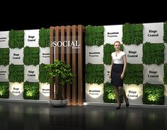 a woman standing in front of a wall with plants on it and the words social